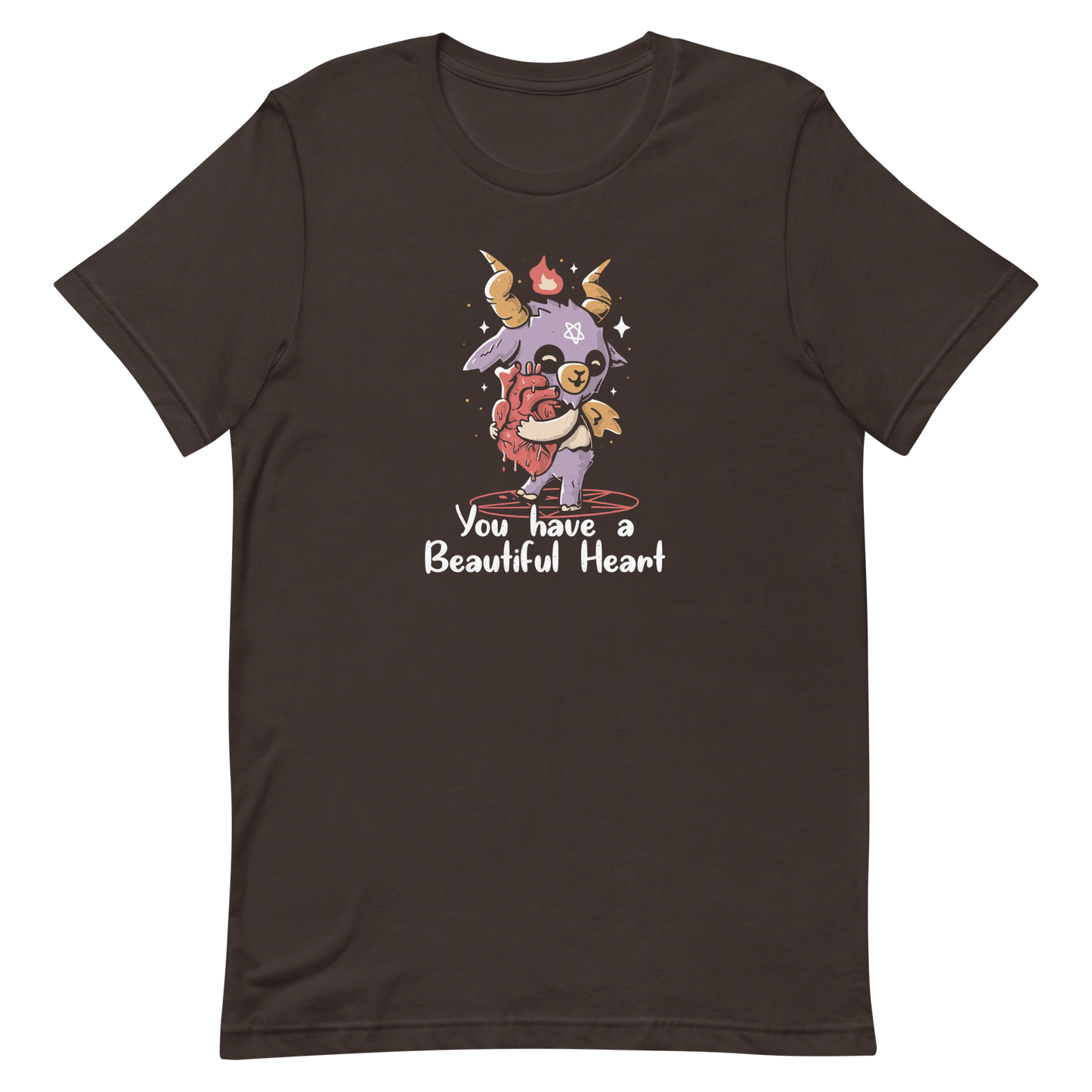 The design features a cute, cartoonish, anthropomorphic goat with big horns and a flame above its head, standing on a red pentagram. The goat has a star on its forehead and is hugging a large, anatomically correct human heart. The text below reads, 'You have a Beautiful Heart'. The image combines elements of occult symbolism with a playful, endearing aesthetic.