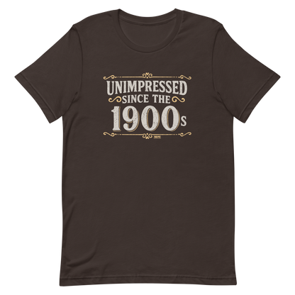 Vintage-style graphic with the phrase “Unimpressed Since the 1900s” in bold distressed lettering, decorated with ornate flourishes and a retro color palette.
