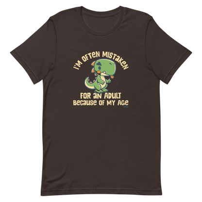 Cute cartoon dinosaur standing with a funny expression, accompanied by the humorous phrase “I’m Often Mistaken for an Adult Because of My Age” in bold distressed lettering.