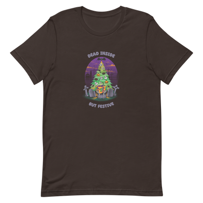 A quirky illustration features a Christmas tree decorated with skulls, pumpkins, and bats, set in a graveyard. The sky is purple and orange, with bats and tombstones surrounding the tree. A skeleton hand holds a festive gift box at the base. Above, text reads "Dead Inside" and below, "But Festive". The design combines Halloween and Christmas elements in a humorous style, highlighting a gothic and festive theme.
