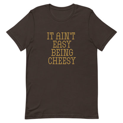 Bold dotted typography spells out ‘It Ain’t Easy Being Cheesy’ in a playful retro style on a yellow background. This funny design mixes wordplay with foodie humor, perfect for pun lovers, cheese fans, retro humor enthusiasts, and anyone who embraces the cringe with pride. A great quirky gift for cheese lovers and humor fans alike.
