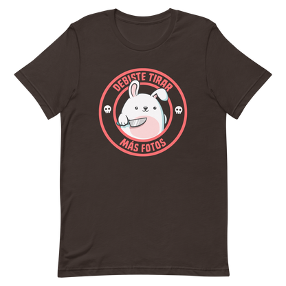 A cute white cartoon bunny with a pink belly stands holding a large kitchen knife in one paw. Surrounding the bunny is a red circular border with the words 'DEBISTE TIRAR MÁS FOTOS'. Small skull icons are on either side of the circle. The overall tone is a mix of adorable and ironic humor.