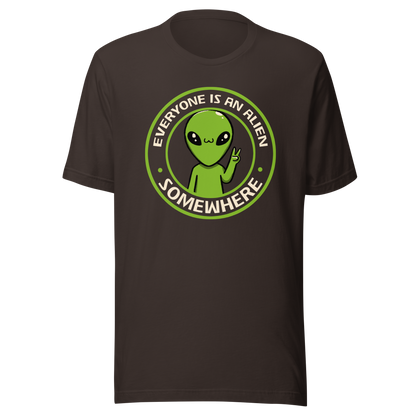 A stamp-style design of a green alien making a “V” sign, paired with the phrase “Everyone Is An Alien Somewhere”. A playful artwork about feeling different and embracing individuality.
