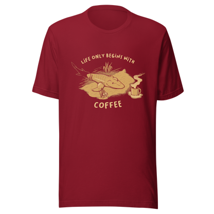 This funny illustration shows a tadpole evolving into a terrestrial creature while reaching for a cup of coffee. Paired with the phrase ‘Life Begins After Coffee Evolution’, the artwork humorously compares human evolution to our daily need for coffee.