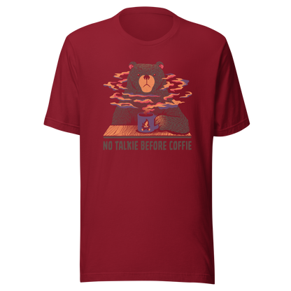 A large brown bear holding a purple coffee cup with a campfire design, with steam rising as if the coffee were piping hot. Below it appears the phrase ‘No Talkie Before Coffie’. A fun design for coffee lovers and anyone who isn’t ready to talk before their first cup.