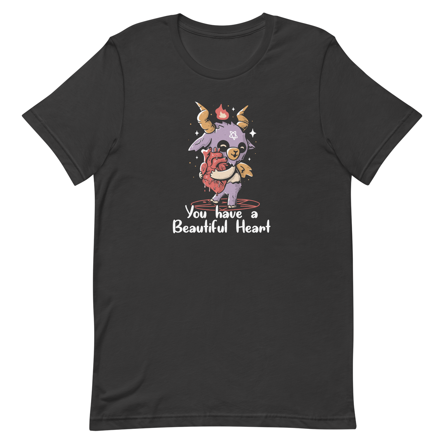 The design features a cute, cartoonish, anthropomorphic goat with big horns and a flame above its head, standing on a red pentagram. The goat has a star on its forehead and is hugging a large, anatomically correct human heart. The text below reads, 'You have a Beautiful Heart'. The image combines elements of occult symbolism with a playful, endearing aesthetic.