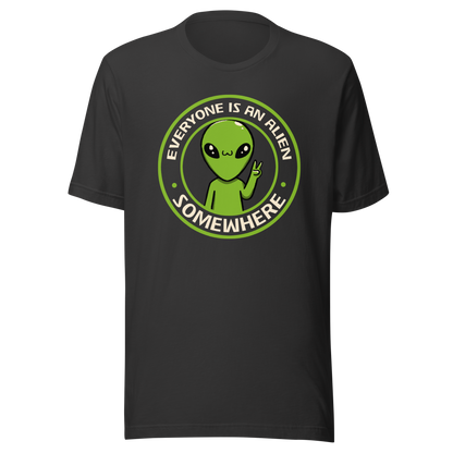 A stamp-style design of a green alien making a “V” sign, paired with the phrase “Everyone Is An Alien Somewhere”. A playful artwork about feeling different and embracing individuality.