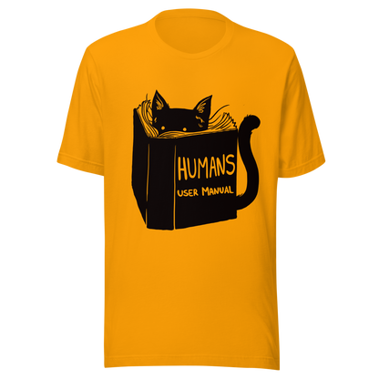 A kitten peeking out from behind a huge book titled "Humans: User Manual". This design plays on the idea that cats are trying to figure out how to control us. Perfect for cat lovers, book fans, and anyone who enjoys lighthearted humor in prints.