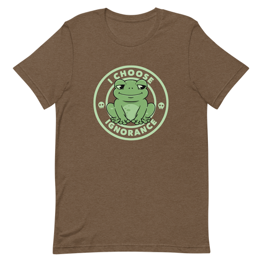 The image shows a cartoonish green frog with a sly smile, sitting with legs splayed out. Around it, the phrase 'I CHOOSE IGNORANCE' is written in bold letters. Two small skull designs are included, one on each side of the frog. The style is playful and ironic, blending elements of humor and rebellion.