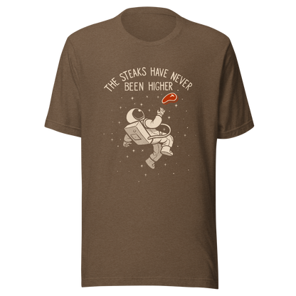 An astronaut floating through space with a small steak in front of him, paired with the phrase ‘The Steaks Have Never Been Higher’. A playful and humorous design that blends space exploration with a clever visual pun. Perfect for fans of witty wordplay and quirky art.