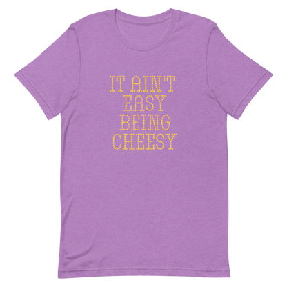 Bold dotted typography spells out ‘It Ain’t Easy Being Cheesy’ in a playful retro style on a yellow background. This funny design mixes wordplay with foodie humor, perfect for pun lovers, cheese fans, retro humor enthusiasts, and anyone who embraces the cringe with pride. A great quirky gift for cheese lovers and humor fans alike.