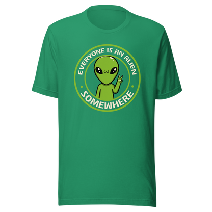 A stamp-style design of a green alien making a “V” sign, paired with the phrase “Everyone Is An Alien Somewhere”. A playful artwork about feeling different and embracing individuality.