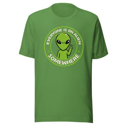 A stamp-style design of a green alien making a “V” sign, paired with the phrase “Everyone Is An Alien Somewhere”. A playful artwork about feeling different and embracing individuality.