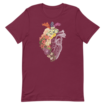 The design is an intricate and anatomical drawing of a human heart on a black background. The left side of the heart morphs into a vibrant assortment of colorful flowers, including roses, daisies, and other blooming blossoms, creating a striking contrast between the realistic and the surreal, symbolizing the harmony between nature and humanity.