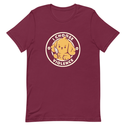 A cute yellow cartoon dog holds a small knife, surrounded by a circular logo that reads 'I Choose Violence'. The dog's expression is serious, yet the overall style is playful and cute. Two small skull icons are on either side, adding an ironic tone to the cheerful design.