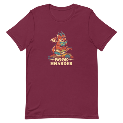 Perched atop his treasure trove of books, this red nerdy dragon is ready to devour epic adventures, magic tales, and fantasy worlds. The words 'BOOK HOARDER' are placed at the bottom of the design.