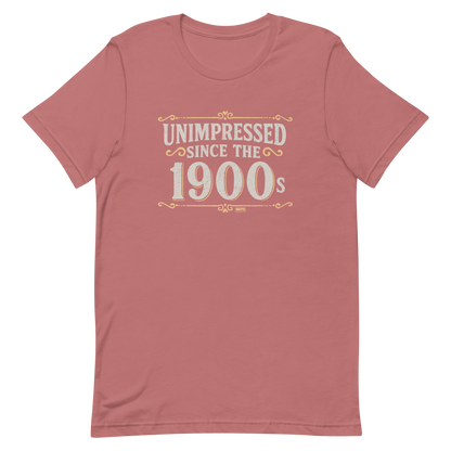 Vintage-style graphic with the phrase “Unimpressed Since the 1900s” in bold distressed lettering, decorated with ornate flourishes and a retro color palette.