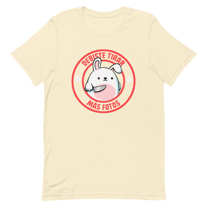A cute white cartoon bunny with a pink belly stands holding a large kitchen knife in one paw. Surrounding the bunny is a red circular border with the words 'DEBISTE TIRAR MÁS FOTOS'. Small skull icons are on either side of the circle. The overall tone is a mix of adorable and ironic humor.