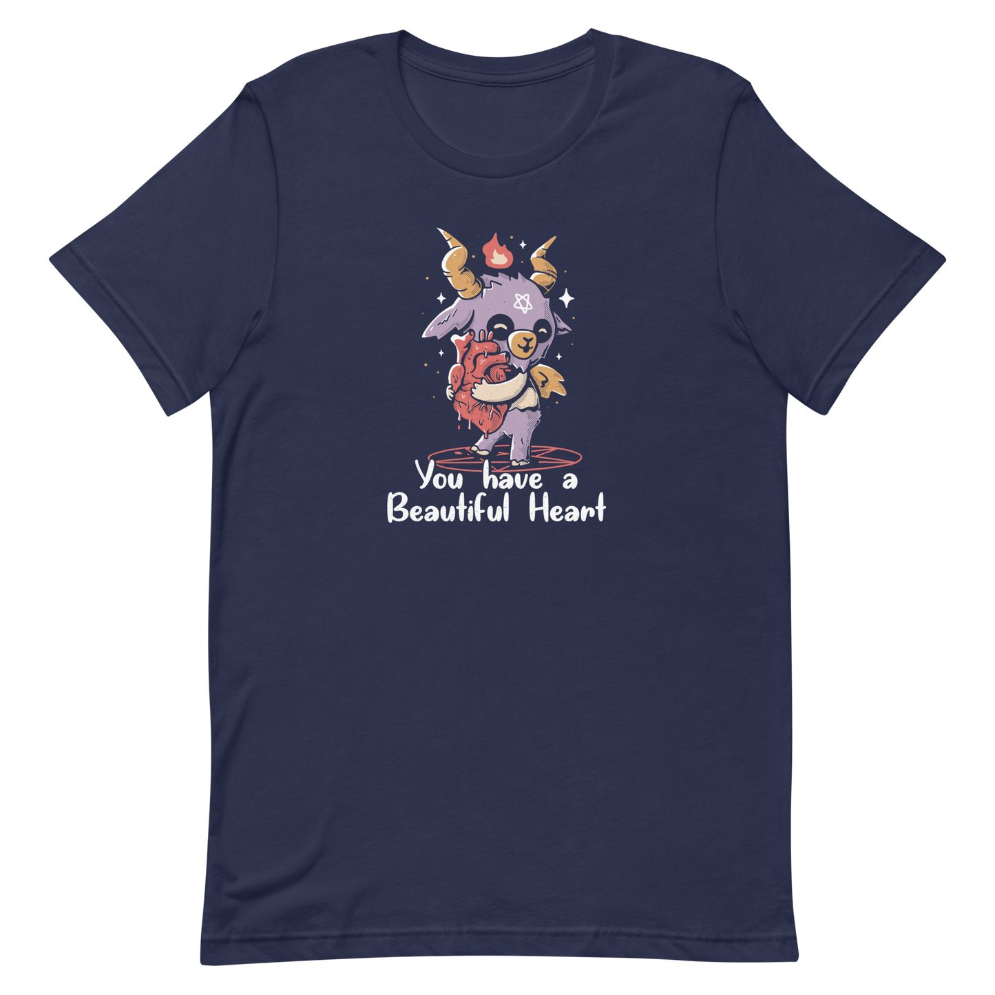 The design features a cute, cartoonish, anthropomorphic goat with big horns and a flame above its head, standing on a red pentagram. The goat has a star on its forehead and is hugging a large, anatomically correct human heart. The text below reads, 'You have a Beautiful Heart'. The image combines elements of occult symbolism with a playful, endearing aesthetic.