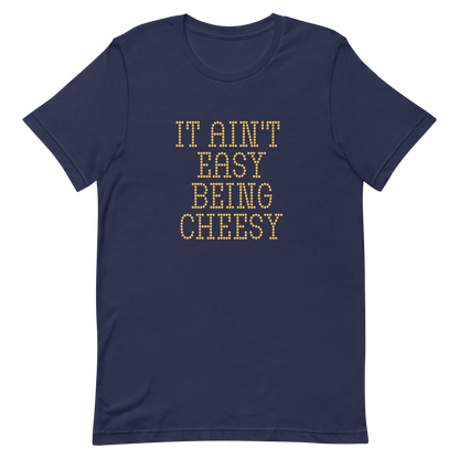 Bold dotted typography spells out ‘It Ain’t Easy Being Cheesy’ in a playful retro style on a yellow background. This funny design mixes wordplay with foodie humor, perfect for pun lovers, cheese fans, retro humor enthusiasts, and anyone who embraces the cringe with pride. A great quirky gift for cheese lovers and humor fans alike.