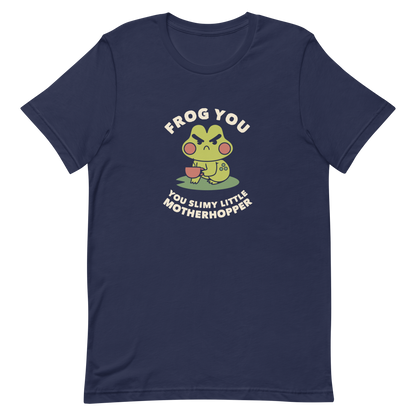 The design features a cartoonish green frog with exaggerated angry features, holding a teacup. The frog has round red cheeks. Above it, text says 'Frog You' and below, 'You Slimy Little Motherhopper'. The style is playful and humorous, reminiscent of cute comic art.