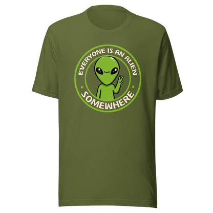 A stamp-style design of a green alien making a “V” sign, paired with the phrase “Everyone Is An Alien Somewhere”. A playful artwork about feeling different and embracing individuality.