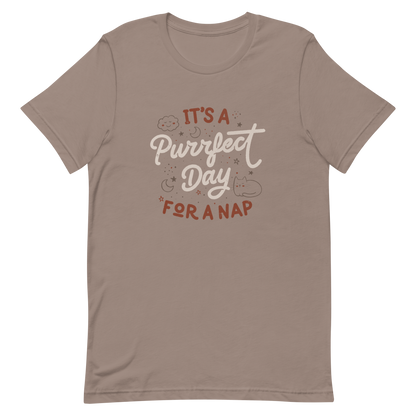 The artwork features the lettering "It's a Purrfect Day for a Nap" in a cute retro style, with a smiling cloud, stars, moons, and a relaxing kitten. This composition plays on the pun of "purrfect" and conveys all the charm of felines in their favorite moment: napping. Ideal for cat lovers, fans of funny phrases, and those who love to transform laziness into a lifestyle.