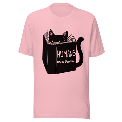 A kitten peeking out from behind a huge book titled "Humans: User Manual". This design plays on the idea that cats are trying to figure out how to control us. Perfect for cat lovers, book fans, and anyone who enjoys lighthearted humor in prints.