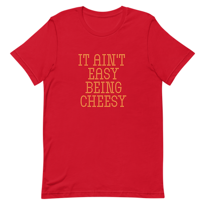 Bold dotted typography spells out ‘It Ain’t Easy Being Cheesy’ in a playful retro style on a yellow background. This funny design mixes wordplay with foodie humor, perfect for pun lovers, cheese fans, retro humor enthusiasts, and anyone who embraces the cringe with pride. A great quirky gift for cheese lovers and humor fans alike.
