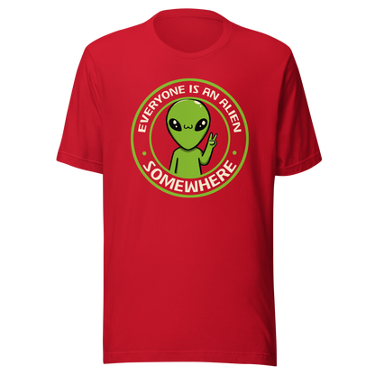 A stamp-style design of a green alien making a “V” sign, paired with the phrase “Everyone Is An Alien Somewhere”. A playful artwork about feeling different and embracing individuality.