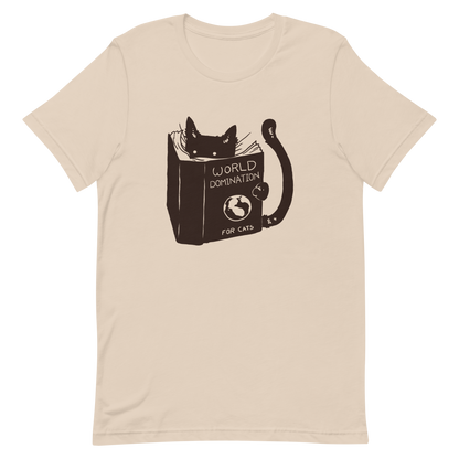 The design features a black silhouette of a cat peeking from behind an oversized book. The book's cover reads 'World Domination for Cats,' and includes a simple drawing of a globe. The cat's eyes are wide open, suggesting either surprise or intense focus on its 'world domination' plans.