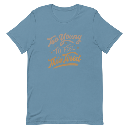The artwork features the vintage-style lettering "Too Young To Feel This Tired," with touches of beige and gold, decorated with small stars. This playful phrase conveys the feeling of premature fatigue with an ironic and stylish touch. Ideal for young adults, students, and anyone who can relate to the daily struggle between energy and exhaustion.
