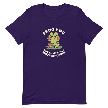 The design features a cartoonish green frog with exaggerated angry features, holding a teacup. The frog has round red cheeks. Above it, text says 'Frog You' and below, 'You Slimy Little Motherhopper'. The style is playful and humorous, reminiscent of cute comic art.