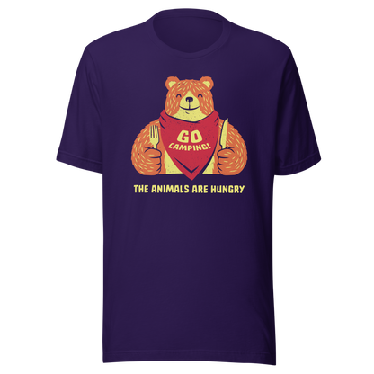 A cute orange bear ready for a meal, holding a fork and knife and wearing a napkin, with the phrase 'Go Camping' and the text 'The Animals Are Hungry' below. A playful and humorous design that pokes fun at the dangers of the wild.
