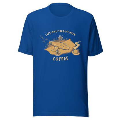 This funny illustration shows a tadpole evolving into a terrestrial creature while reaching for a cup of coffee. Paired with the phrase ‘Life Begins After Coffee Evolution’, the artwork humorously compares human evolution to our daily need for coffee.