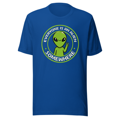 A stamp-style design of a green alien making a “V” sign, paired with the phrase “Everyone Is An Alien Somewhere”. A playful artwork about feeling different and embracing individuality.